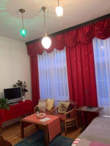 a living room with red curtains and a couch and a table at Villa Pazelt Top1 in Bad Vöslau