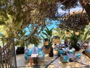 a restaurant with tables and chairs under a tree at Le Calette N.5 in Cefalù