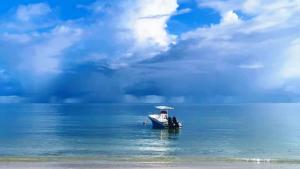 a small boat in the middle of the water at Seashell Beach Villa in Grand'Anse Praslin