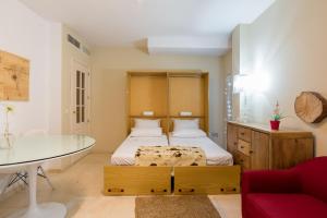 um pequeno quarto com uma cama e uma mesa de vidro em GR0-Quiet apartment, Private backyard, Walk to Old Town em Málaga