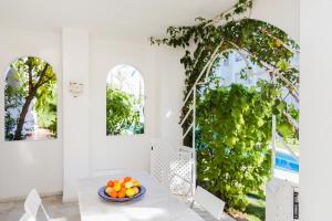 a room with a table with a bowl of oranges on it at Oasis Club II Triplex Apartment by Rock Rentals in Jávea