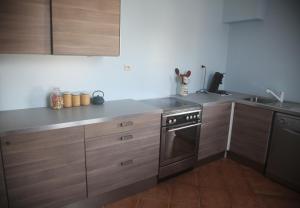 a kitchen with wooden cabinets and a sink and a stove at La Maison De Maria in Folembray