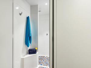a sliding glass door with a blue umbrella in a bathroom at hotelF1 Laval in Chang&eacute;