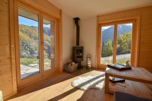 a living room with large windows and a table at Chalet Le Cerf - Newly build - WOW Views! in La Tzoumaz