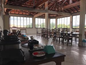 a large room with tables and chairs and windows at Hospedaria Casa Real in Santa Cruz de Minas
