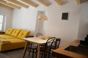 ein Wohnzimmer mit einem gelben Sofa und einem Tisch in der Unterkunft Apartments MartaMare in Martinšćica