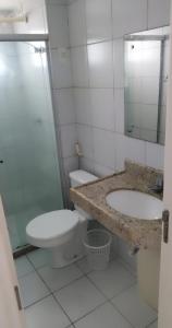 y baño con aseo, lavabo y espejo. en Edificio Verano, en Natal
