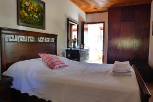 een slaapkamer met een groot bed met een houten hoofdeinde bij Lola's Cottage & Garden in Kalokhorio