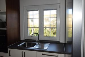 a kitchen with a sink and two windows at Ferienwohnung Auszeit in Dornbirn