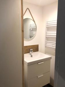 een witte badkamer met een wastafel en een spiegel bij L'Aire des montagnes in Bolquere Pyrenees 2000
