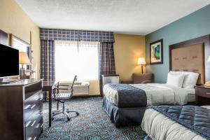 a hotel room with two beds and a desk at Clarion Inn New London - Mystic in New London