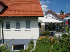 ein weißes Haus mit orangefarbenem Dach in der Unterkunft Ferienwohnung Emilia in Münsingen