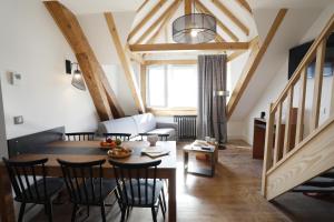 een woonkamer met een tafel en stoelen en een woonkamer bij RESIDENCE LE SPLENDID in Villard-de-Lans