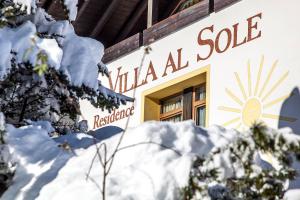 ein schneebedecktes Gebäude mit dem Schild für den Verkauf von Mineralien in der Unterkunft Residence Villa al Sole in Wolkenstein in Gröden