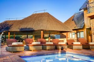 a large pavilion with chairs and a pool at Zebula 8 Bedroom Lodge – IV1 in Mabula