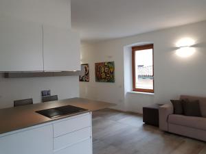 a kitchen and living room with a counter and a couch at Dimora diffusa Sannicolò al Fiume in Rovereto