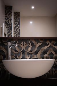 a white sink in a bathroom with a tiled wall at Zanhotel Europa in Bologna