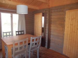 een eetkamer met een houten tafel en stoelen bij Vakantiepark t Urkerbos - Blokhutje in Urk