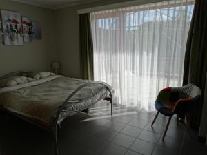 a bedroom with a bed and a large window at Vakantieverblijf Berg en Dal in Heuvelland