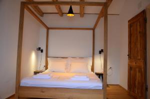 a bedroom with a canopy bed with white sheets at Apartments MartaMare in Martinšćica