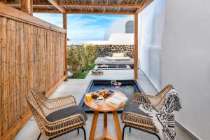 a patio with a table and chairs on a balcony at Callia Retreat Suites - Adults Only in Fira