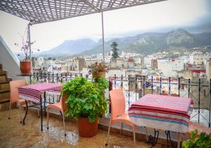 uma varanda com mesas e cadeiras e vista para uma cidade em Dar Rehla em Tetouan