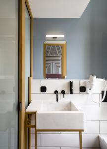 a bathroom with a white sink and a mirror at Colors Urban Hotel Thessaloniki in Thessaloniki