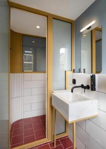 a bathroom with a sink and a shower at Colors Urban Hotel Thessaloniki in Thessaloniki