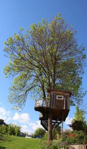 a tree house in front of a tree at Urlaub am Bauernhof Weichselbaum in Schloss Rosenau