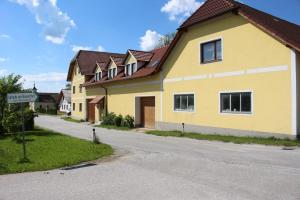 ein gelbes Haus am Straßenrand in der Unterkunft Urlaub am Bauernhof Weichselbaum in Schloss Rosenau