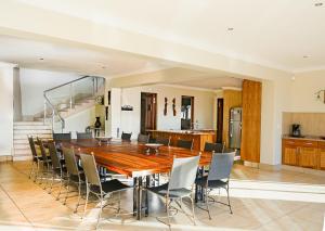 ein Esszimmer mit einem Holztisch und Stühlen in der Unterkunft Zebula 8 Bedroom Lodge – IV1 in Mabula