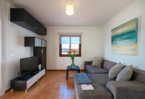 a living room with a couch and a tv at Villas El Partidor in Playa Blanca