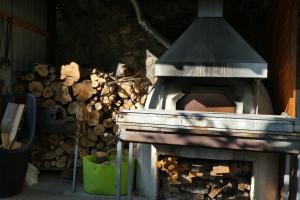 einem Außenofen mit einem Haufen Feuerholz in der Unterkunft Lola's Cottage & Garden in Kalokhorio