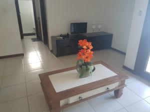 a vase with orange flowers sitting on a table at Porto das Baleias Praia do Forte in Praia do Forte