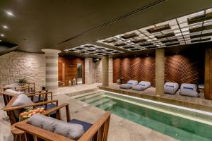 a pool in a house with chairs and a table at Boutique Hotel & Spa Casa del Mare - Mediterraneo in Herceg-Novi