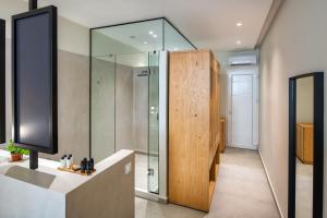 a bathroom with a shower with a glass door at Callia Retreat Suites - Adults Only in Fira