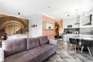 a living room with a couch and a kitchen at Zefiro Chmielna in Gdańsk