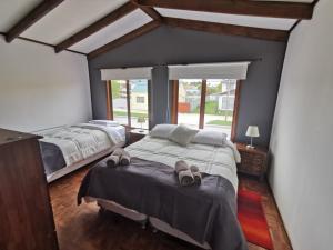 duas camas num quarto com chinelos na cama em SHEUEN PATAGONIA em Puerto Natales