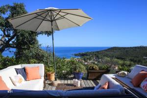 a person sitting on a couch under an umbrella at Villa Vista Mare Residence Serenamore in Favone