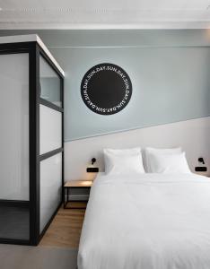 a bedroom with a white bed and a black mirror at Colors Urban Hotel Thessaloniki in Thessaloniki