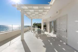 a balcony with a table and chairs and the ocean at Villa Diamante by BarbarHouse in Maruggio