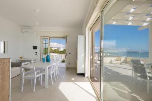 a dining room with a table and a view of the ocean at Villa Diamante by BarbarHouse in Maruggio
