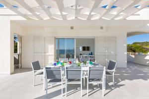 a white dining room with a table and chairs at Villa Diamante by BarbarHouse in Maruggio +39 photos