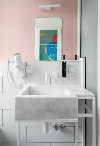 a bathroom with a white sink and a mirror at Colors Urban Hotel Thessaloniki in Thessaloniki