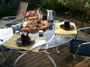 a glass table with a plate of food on it at Chambres d'Hôtes Les Ifs in Montsûrs