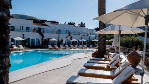 a swimming pool with lounge chairs and an umbrella at Le Calette Bay in Cefalù