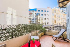 a balcony with a red table and chairs on a building at CARRE D'OR TERRACE AP4015 NICE by Riviera Holiday Homes in Nice