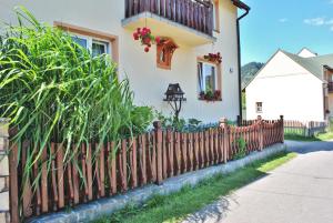 una valla de madera frente a una casa en Pokoje u Danusi en Sromowce Niżne