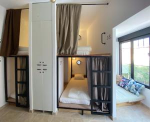 two bunk beds in a room with a window at Hostel Numero Trece - Albergue Juvenil - FREE towels, coffee & tea, remote check-in in Alicante