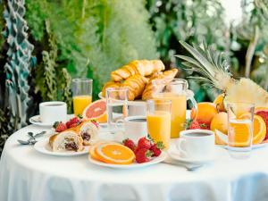 una mesa llena de alimentos para el desayuno y zumo de naranja en Villa La Fenice en Reggio Calabria